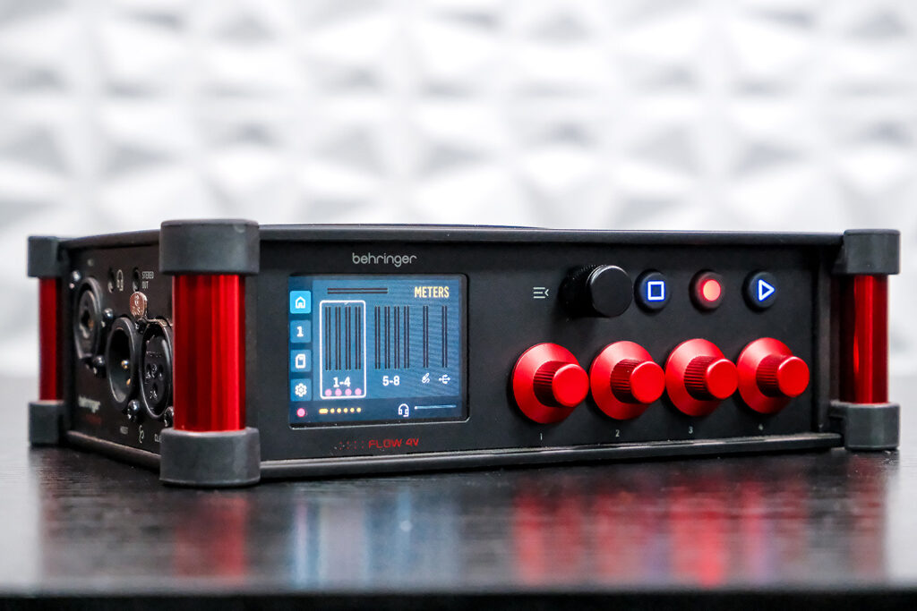 The Behringer Flow 4V front panel with touchscreen, transport controls, and channel level knobs